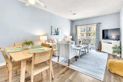 a living room with a dining table and a couch at Coastside in Santa Rosa Beach