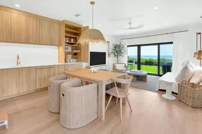 a kitchen and living room with a wooden table and chairs at Psalms in Santa Rosa Beach