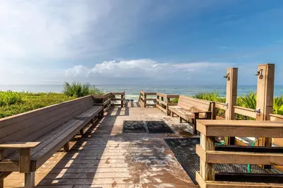 a row of benches on a walkway to the beach at Paradise Palms in Santa Rosa Beach