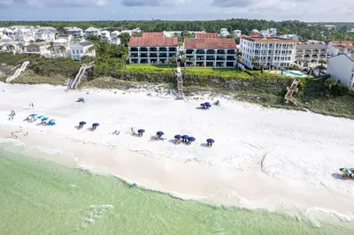 an aerial view of a beach with people and umbrellas at Paradise Palms in Santa Rosa Beach