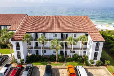an aerial view of a building with palm trees and the ocean at Paradise Palms in Santa Rosa Beach