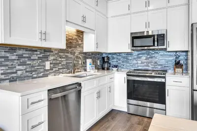 a kitchen with white cabinets and a stainless steel dishwasher at Paradise Palms in Santa Rosa Beach