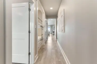 a hallway with white walls and a long hallway with a mirror at Sea Palms in Santa Rosa Beach