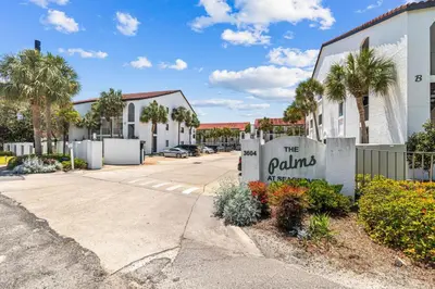 a sign in front of a building with palm trees at Sea Palms in Santa Rosa Beach