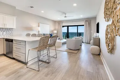 a kitchen and living room with a table and chairs at Sea Palms in Santa Rosa Beach
