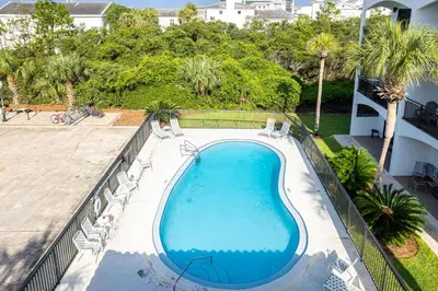 an overhead view of a swimming pool with chairs and trees at Palms of Seagrove D5 in Santa Rosa Beach