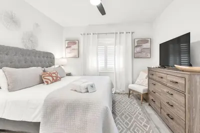 a bedroom with a bed and a tv and a dresser at Palms of Seagrove D5 in Santa Rosa Beach