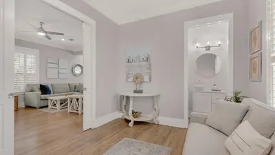 a white living room with a couch and a table at Magnolia Breeze in Santa Rosa Beach