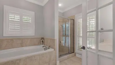 a bathroom with a tub and a glass shower at Magnolia Breeze in Santa Rosa Beach