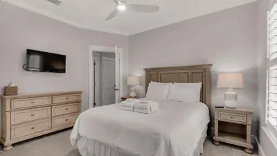 a bedroom with a white bed with two towels on it at Magnolia Breeze in Santa Rosa Beach