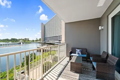 a balcony with chairs and a view of the water at Resort-Style Lake-View Condo, 5 Pools, Hot Tubs, Walk to Beach in Panama City Beach