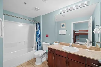a bathroom with a sink and a toilet and a mirror at Resort-Style Lake-View Condo, 5 Pools, Hot Tubs, Walk to Beach in Panama City Beach