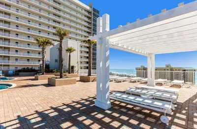a white pergola with a bench and a building at Resort-Style Lake-View Condo, 5 Pools, Hot Tubs, Walk to Beach in Panama City Beach
