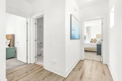 a white room with a bathroom and a bedroom at Salty Sons in Inlet Beach