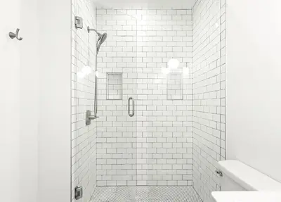 a white bathroom with a shower with white tiles at The Palms in Santa Rosa Beach