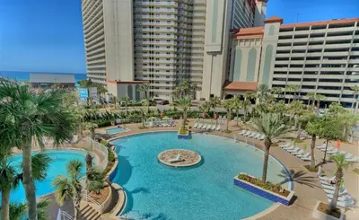 an overhead view of a pool with palm trees and buildings at Lake-View Condo Near Beach,5 Pools, 2 Hot Tubs, Balcony & Resort Amenities in Panama City Beach