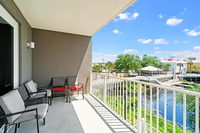 a balcony with chairs and a view of the water at Lake-View Condo Near Beach,5 Pools, 2 Hot Tubs, Balcony & Resort Amenities in Panama City Beach