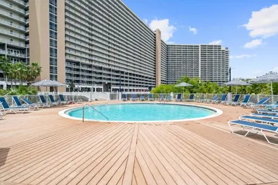 a large swimming pool with chairs and a building at Lake-View Condo Near Beach,5 Pools, 2 Hot Tubs, Balcony & Resort Amenities in Panama City Beach
