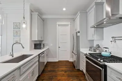 a white kitchen with a sink and a stove at Om Sweet Om in Seagrove Beach