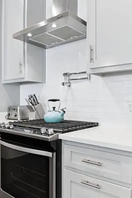 a kitchen with a stove with a blue pot on it at Om Sweet Om in Seagrove Beach