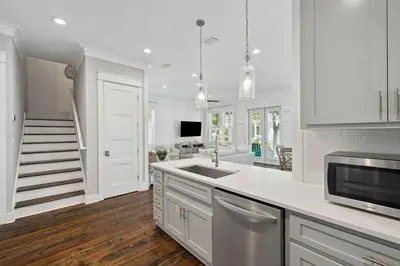 a kitchen with white cabinets and a sink at Om Sweet Om in Seagrove Beach
