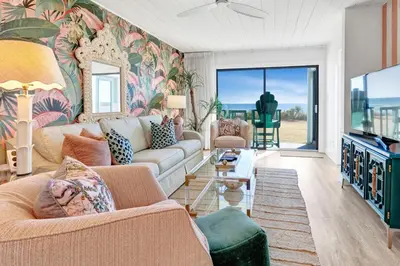 a living room with a couch and a tv at Seagroovy in Seagrove Beach
