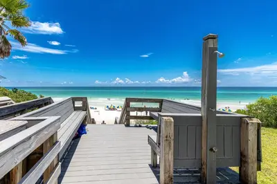 a boardwalk to the beach with the ocean in the background at Seagroovy in Seagrove Beach