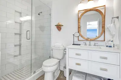 a bathroom with a toilet and a shower and a mirror at Seagroovy in Seagrove Beach