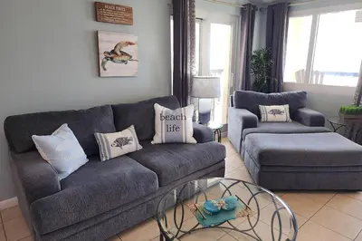 a living room with a couch and a chair and a table at Oceanfront Condo - Balcony Views & Beach Access in Panama City Beach