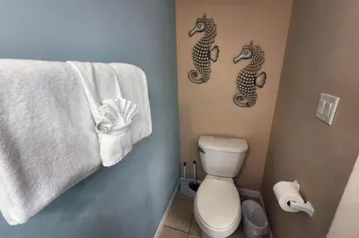 a bathroom with a toilet and two seahorses on the wall at Oceanfront Condo - Balcony Views & Beach Access in Panama City Beach
