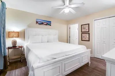 a bedroom with a white bed and a ceiling fan at Tidewater 3006 by Emerald Cost Retreats in Panama City Beach