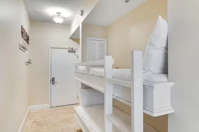 a white bunk bed in a room with a shower at Tidewater 3006 by Emerald Cost Retreats in Panama City Beach