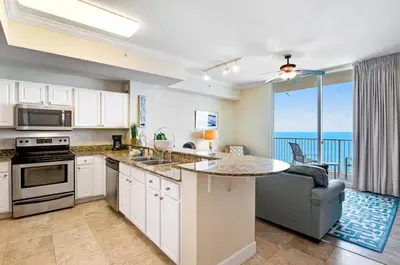 a kitchen with a counter top and a view of the ocean at Tidewater 3006 by Emerald Cost Retreats in Panama City Beach
