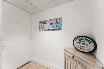 a white room with a clock on the wall at Sunbird low Floor 2BR! Free Beach Chair Service! by Dolce Vita Getaways PCB in Panama City Beach