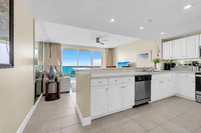 a kitchen with white cabinets and a view of the ocean at BeachFront- 5 Pools, Starbucks, Movies - Majestic Beach Resort in Panama City Beach