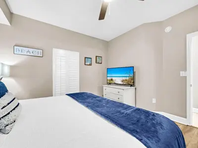 a bedroom with a bed and a flat screen tv at BeachFront- 5 Pools, Starbucks, Movies - Majestic Beach Resort in Panama City Beach