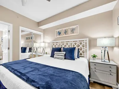 a bedroom with a large bed with blue pillows at BeachFront- 5 Pools, Starbucks, Movies - Majestic Beach Resort in Panama City Beach