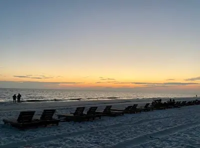 a row of beach chairs on the beach at sunset at Best beachfront value in PCB! Incredible view! in Panama City Beach