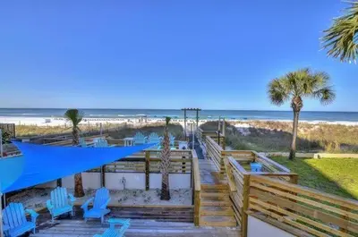 a boardwalk leading to the beach with blue chairs and palm trees at Best beachfront value in PCB! Incredible view! in Panama City Beach