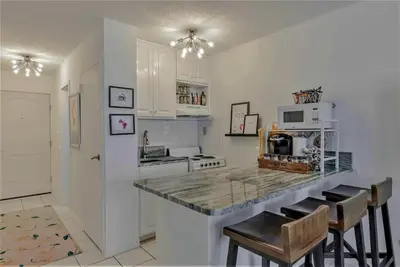 a kitchen with a counter and some chairs in it at Best beachfront value in PCB! Incredible view! in Panama City Beach