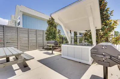 a backyard with a barbecue grill and a picnic table at Easy Beach Access New PCB Retreat with Resort Pool! in Panama City Beach