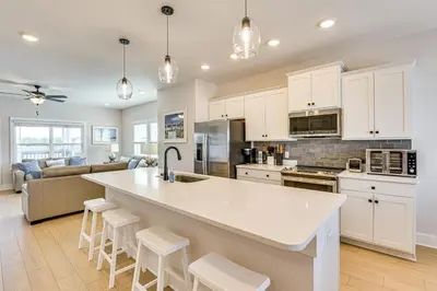 a kitchen and living room with a large white island at Easy Beach Access New PCB Retreat with Resort Pool! in Panama City Beach