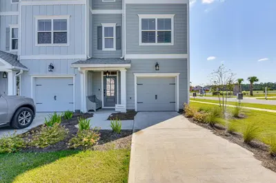 a house with two garage doors and a driveway at Easy Beach Access New PCB Retreat with Resort Pool! in Panama City Beach