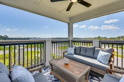 a living room with a couch and a table on a balcony at Easy Beach Access New PCB Retreat with Resort Pool! in Panama City Beach