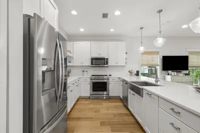 a kitchen with white cabinets and a stainless steel refrigerator at Sweet Sea-esta on 30A in Inlet Beach