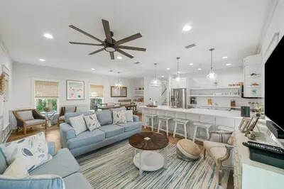 a living room with a blue couch and a kitchen at Sweet Sea-esta on 30A in Inlet Beach