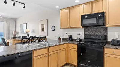 a kitchen with a sink and a microwave at 2 Beachfront Condos BBQ Balconies Resort Pool Hot Tub Direct Beach Access in Panama City Beach