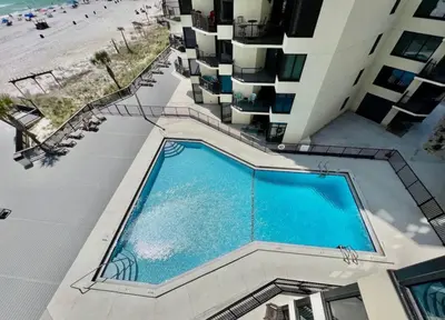 an overhead view of a swimming pool next to a beach at Renovated Penthouse! Free Beach Chairs Included! by Dolce Vita Getaways PCB in Panama City Beach