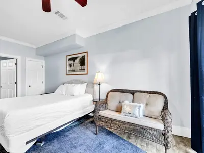 a bedroom with a bed and a chair at 3B - The Seaglass Shack in Panama City Beach