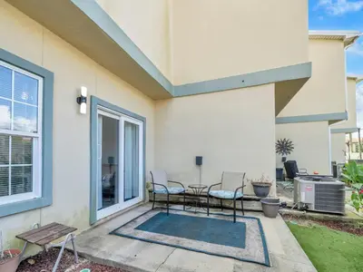 a patio with chairs and a table in front of a house at 3B - The Seaglass Shack in Panama City Beach